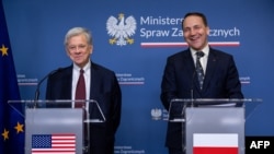 Cпэцыяльны прадстаўнік прэзыдэнта ЗША Джон Коўл (зьлева) і міністар замежных справаў Польшчы Радаслаў Сікорскі на прэсавай канфэрэнцыі ў Міністэрстве замежных спраў Польшчы ў Варшаве, 28 красавіка 2026 году