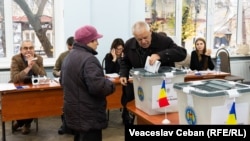 Moldoveni cu cetățenia română votează la o secție din Chișinău pentru alegerea președintelui României, 22 noiembrie.