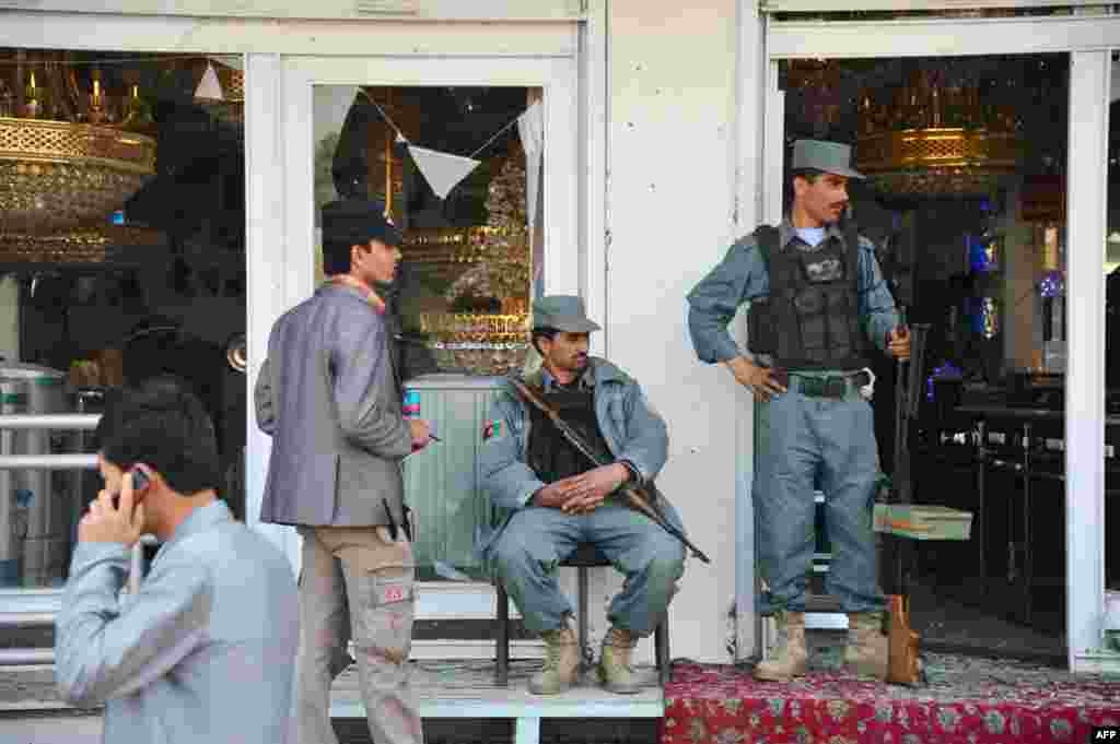 Afghan security personnel secure the front of a damaged building a day after insurgents used the building to attack the parliament building in Kabul. (AFP)