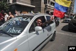 Вэнэсуэлец, які жыве ў Чылі, едзе з нацыянальным сьцягам, а на машыне надпіс «Свабодная Вэнэсуэла»