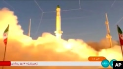 In this frame grab from Iran state TV video footage from June 26, an Iranian satellite-carrier rocket blasts off from an undisclosed location in Iran -- an event which drew a rebuke from Washington.
