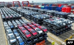 Новые автомобили ожидают погрузки на грузовой корабль в порту Сучжоу на востоке Китая