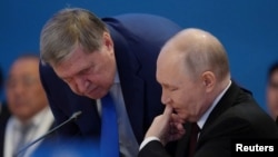 Președintele rus Vladimir Putin discută cu consilierul său, Iuri Ușakov