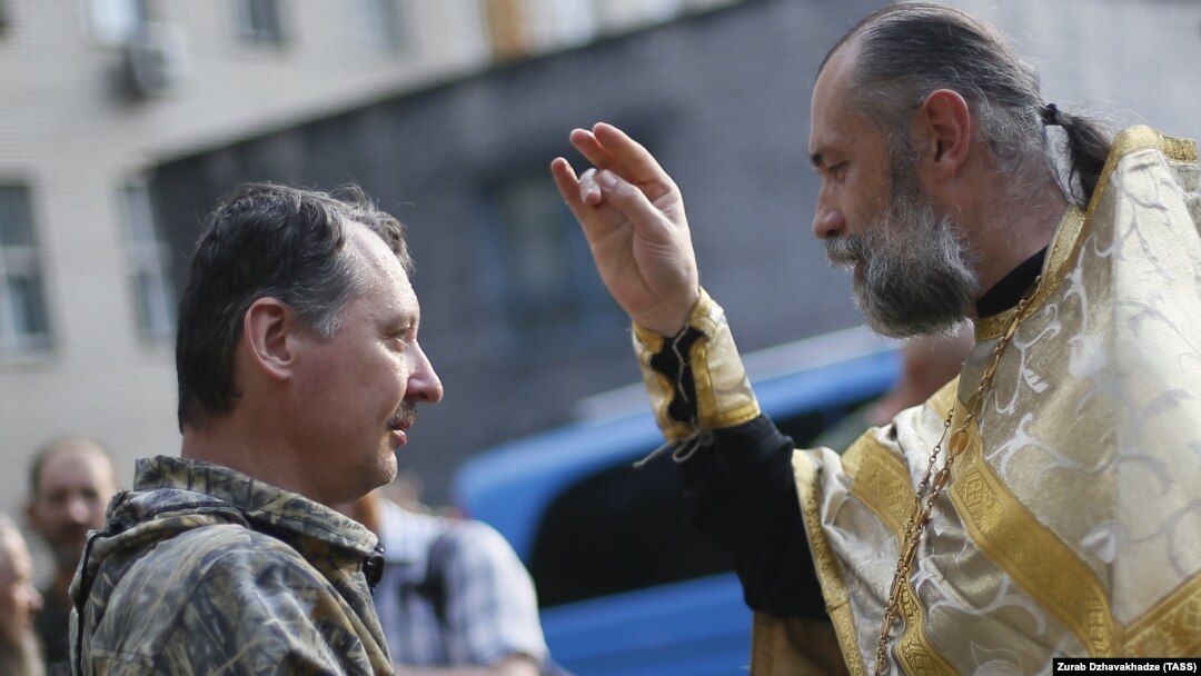 An Orthodox priest blesses pro-Russian separatist commander Igor Strelkov (left) during a religious service in the eastern city of Donetsk on July 10.