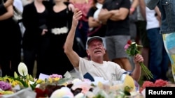 Persoanele îndoliate depun flori la un memorial pe plaja Bondi din Sydney.