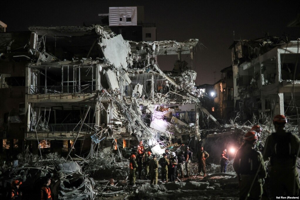 Punonjës të shpëtimit dhe sigurisë duke u angazhuar në një vend të prekur nga një sulm iranian, në Ramat Gan, më 13 qershor.