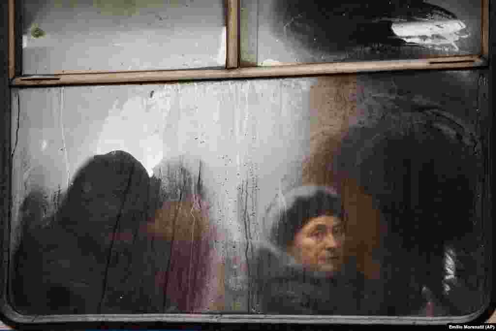 Commuters are seen through the window of a public bus as they travel in central Vinnytsia, Ukraine. (AP/Emilio Morenatti)