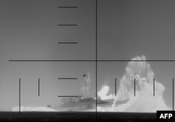 This frame grab from a video released by the US Department of Defense on March 4 shows what it says is periscope footage of a US Navy submarine firing on and sinking an Iranian warship in the Indian Ocean.