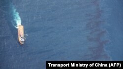 Chnese offshore supply ship "De Shen" works at an oil spill area during a clean-up operation at sea off the coast of eastern China, Janiary 15, 2018