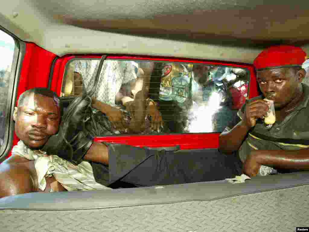 A suspected assassin for exiled Hatian president Jean Bertrand Aristide's Lavalas party being held in a car in Petit Goave, Haiti March 3, 2004. REUTERS/Daniel Aguilar 