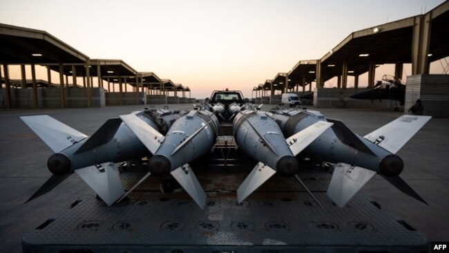 На этом снимке, предоставленном Пентагоном и сделанном 18 декабря 2025 года в неустановленном месте, военнослужащие ВВС США загружают боеприпасы на самолеты F-15E Strike Eagle, готовящиеся к нанесению авиаударов по объектам ИГИЛ в Сирии