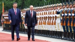 Владимир Путин и председатель КНР Си Цзиньпин осматривают почётный караул во время церемонии приветствия в Доме народных собраний (китайском парламенте) в Пекине, 20 мая 2026 года