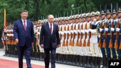 Голова Китаю Сі Цзіньпін і президент Росії Володимир Путін проходять перед вартою почесного караулу, Пекін, 20 травня 2026 року