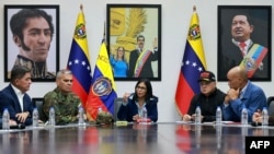 Venesuela prezidentinin səlahiyyətlərini icra edən Delsi Rodriqes (mərkəzdə) müdafiə naziri Vladimir Padrino (soldan ikinci) və digər rəsmilərlə görüşür.