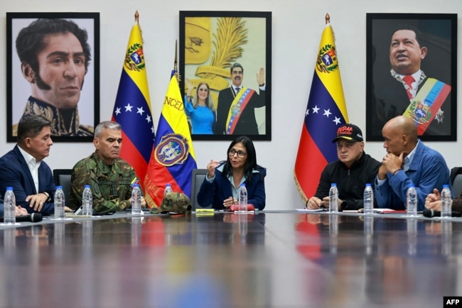 Delcy Rodríguez në një takim urgjent në pallatin presidencial Miraflores. Pranë saj janë ministri venezuelian i mbrojtjes Vladimir Padrino López (majtas) dhe ministri i brendshëm venezuelian Diosdado Cabello (djathtas). Karakas, 4 janar 2026, një ditë pas operacionit ushtarak amerikan.