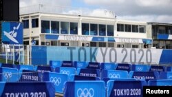 Вывески Олимпийских игр-2020 в Токио на пляже Цуригасаки, месте проведения соревнований по серфингу, в городе Ичиномия, префектура Тиба, Япония. 18 июля 2021 года