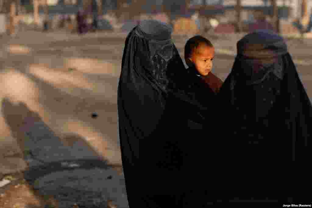 Burqa-clad women and a child, who are among displaced Afghan families fleeing the violence in their provinces, stay in a makeshift shelter at Shahr-e Naw park, in Kabul, Afghanistan October 4, 2021.&nbsp;