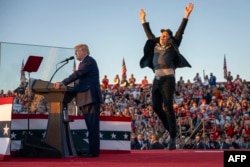 Ілон Маск скаче на сцені під час виступу Дональда Трампа на мітингу перед виборцями в містечку Батлер, штат Пенсильванія. 5 жовтня 2024 року