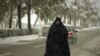 A woman walks on a street during a rare autumn snowstorm in Tehran. (Photo for Reuters by Caren Firouz)