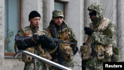 Pro-Russian gunmen stand guard outside the mayor's office in Slovyansk, Ukraine, on April 14. Can Kyiv prove some are Russian servicemen?