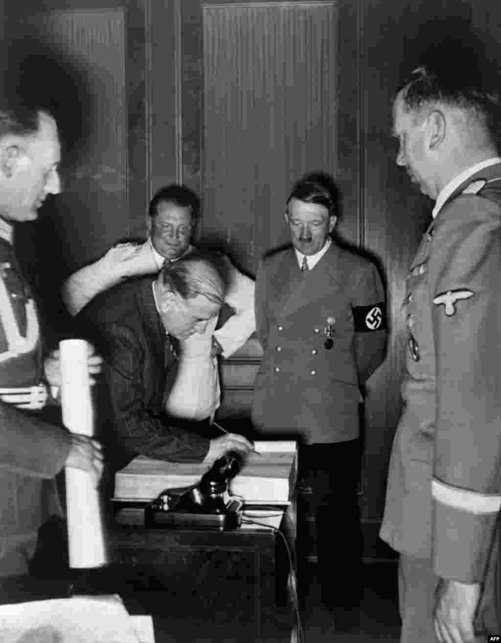 French Prime Minister Daladier signs the Munich Agreement as Hitler (second right), Reichsmarshal Hermann Goering (third left), Hitler's secretary Martin Bormann (right), and top Nazi officers look on. France refused to fight Germany alone and followed the British lead, despite a military pact with Czechoslovakia.