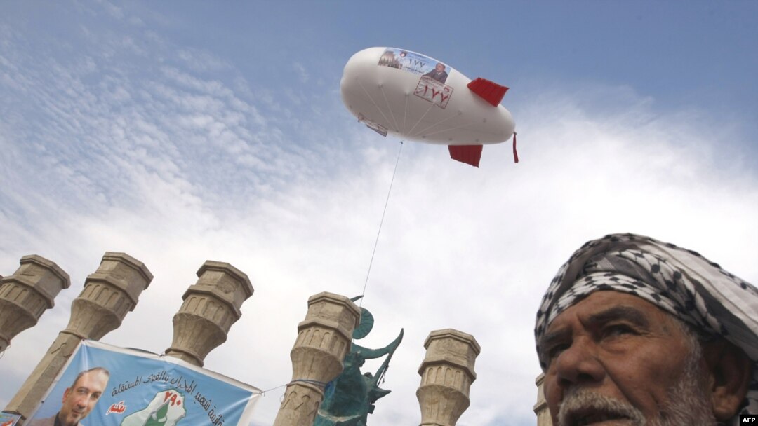 A man walks past campaign promotions in central Baghdad on January 29.