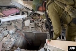 Израильский солдат, проверяющий, как он говорит, вход в туннель, используемый "Хамас" в секторе Газа. 3 ноября 2023 года