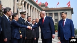 Američki predsjednik Donald Trump rukuje se sa Zheng Shanjieom, predsjednikom kineske Nacionalne komisije za razvoj i reforme, dok kineski predsjednik Xi Jinping (desno) posmatra u Velikoj dvorani naroda u Pekingu, 14. maja.
