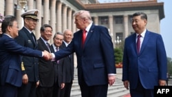 US President Donald Trump shakes hands with Zheng Shanjie, chairman of China's National Development and Reform Commission, as Chinese leader Xi Jinping (right) looks on at the Great Hall of the People in Beijing on May 14. 