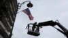 A worker hangs a U.S. flag on a lamppost along a street where the U.S. Consulate in located in Jerusalem.