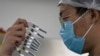 CHINA -- A worker inspects syringes of a vaccine for COVID-19 produced by Sinovac at its factory in Beijing, September 24, 2020