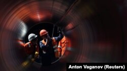 Workers are seen through a pipe at the construction site of the Nord Stream 2 gas pipeline. (File photo)