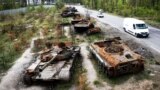 UKRAINE – Cars pass by destroyed Russian tanks in a recent battle against Ukrainians in the village of Dmytrivka, close to Kyiv, May 23, 2022