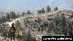 A soldier stands guard along the border fence at the Angoor Adda outpost on the border with Afghanistan in South Waziristan on October 18.