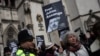 Ofițerii de poliție stau de pază în timp ce susținătorii fondatorului WikiLeaks, Julian Assange, țin pancarte în fața Curții Regale de Justiție, Înalta Curte a Marii Britanii, în centrul Londrei, 26 martie 2024.