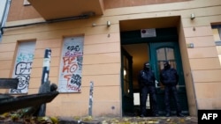 Rendőrök őrzik egy ház bejáratát Berlin Friedrichshain kerületében a Németországban betiltott Hamász elleni razzia során, 2023. november 23-án