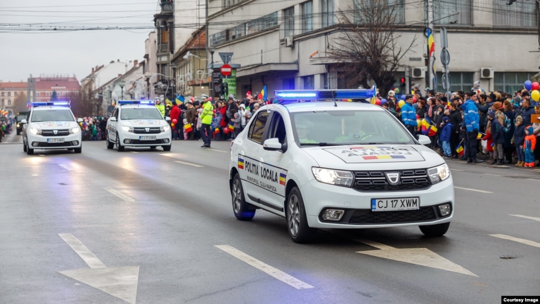 În România sunt 11.000 de polițiști locali, care lucrează în 624 de secții. Ei ar trebui să vegheze la liniștea oamenilor și să rezolve problemele apărute în comunitățile locale. În imagine: trei autoturisme ale Poliției Locale participă la parada de ziua națională, la Cluj. 