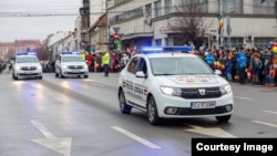 În toată țara sunt 11.000 de polițiști locali, care lucrează în 624 de secții, și care ar trebui să vegheze la liniștea oamenilor și să le rezolve problemele. În imagine: trei autoturisme participă la parada de ziua națională, la Cluj-Napoca. 