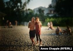 Teenagers pose for a photo while hanging out with friends on a beach on the Vorskla River in Poltava.