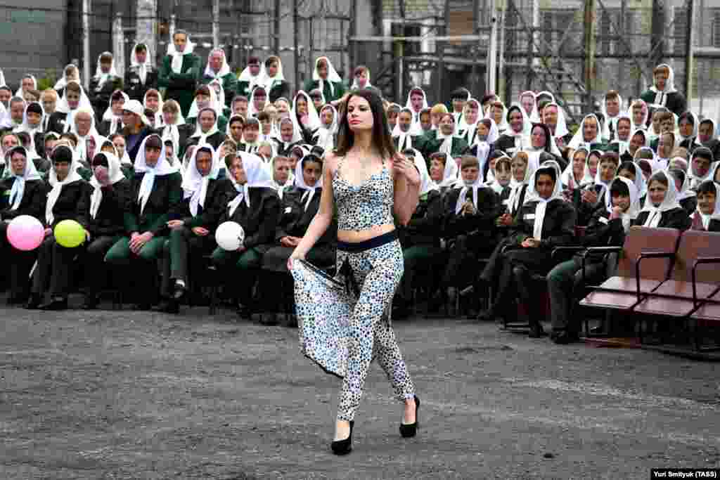 A convict showcases one of her creations during a fashion show at female penal colony No. 10 in the village of Gornoye. Prisoners of the colony sew clothes at a garment factory and every year they celebrate Day of Light Industry by presenting the clothes they made. (TASS/Yuri Smityuk)