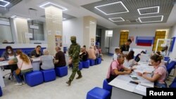 Helyi lakosok orosz állampolgárságot és útlevelet igényelnek az ukrajnai Herszon városában, 2022. július 25-én