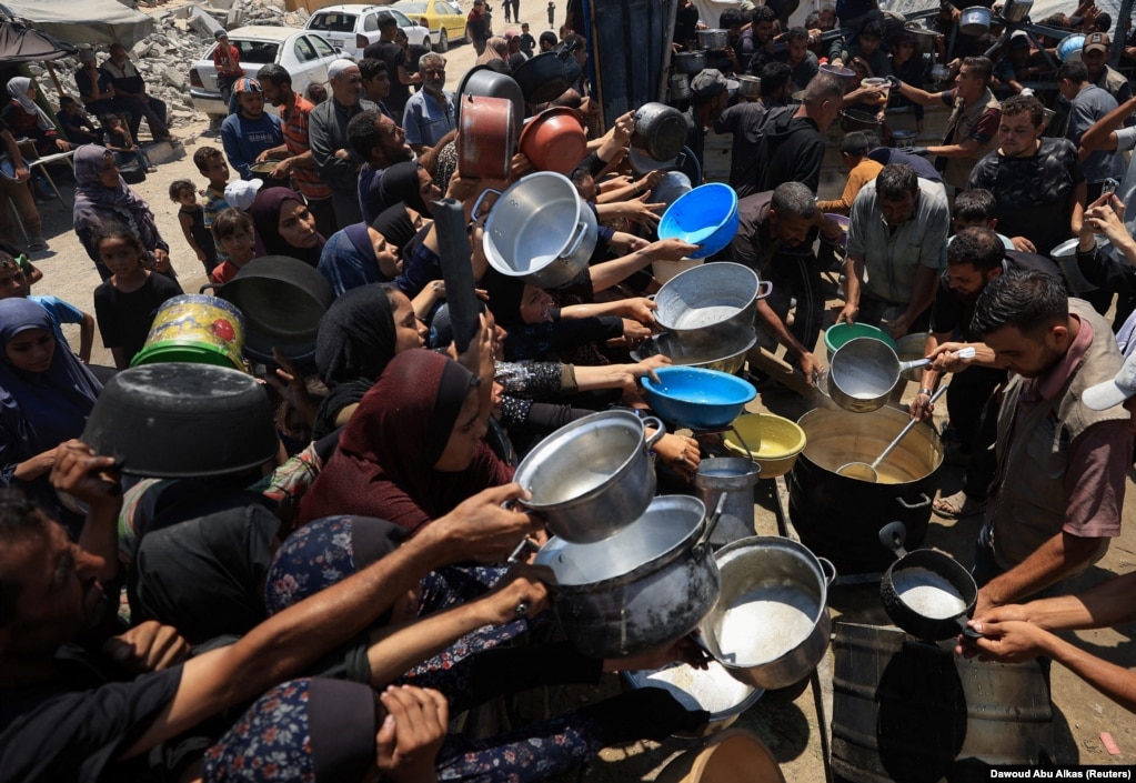 Palestinezë duke marrë ushqim nga një kuzhinë popullore, në Qytetin e Gazës, më 22 korrik.