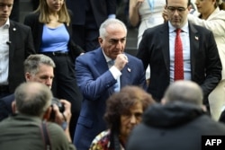 The son of Iran's last shah, exiled crown prince Reza Pahlavi (center), leaves after a press conference in Berlin on April 23.