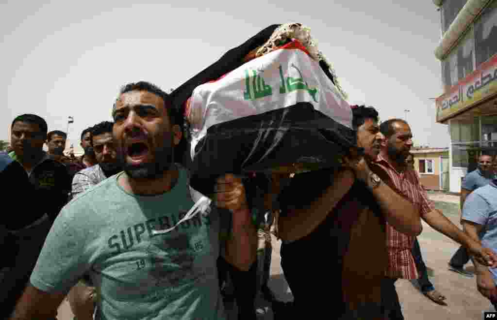 Iraqi men carry a coffin in the holy Iraqi city of Najaf on July 3 during a funeral procession for the victims of a suicide bombing that ripped through Baghdad&#39;s busy shopping district of Karrada. (AFP/Haidar Hamdani)