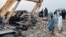 Люди на месте разрушенного полицейского поста в Банну, Пакистан, 10 мая 2026 года