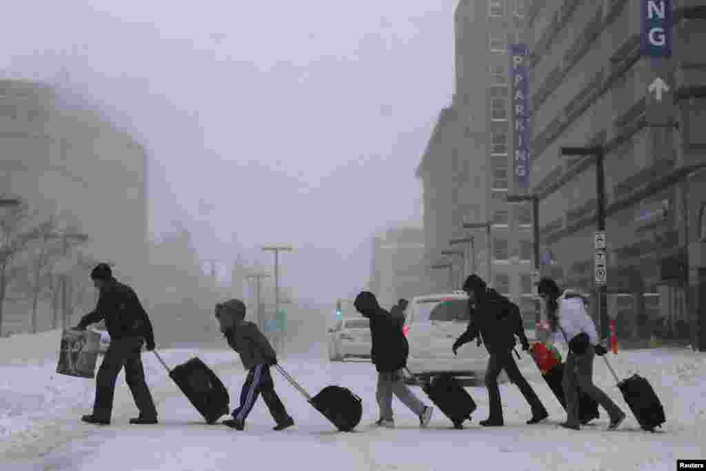 Travelers leave a train station in Boston, Massachusetts, where nearly two feet (60 centimeters) of snow fell in some areas. 