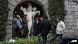 Iranian journalists try to escape the rain during Iranian nuclear talks in Lausanne.