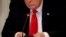 Donald Trump, az Amerikai Egyesult Államok elnöke, mobiltelefonját használja.