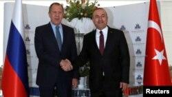 Russian Foreign Minister Sergei Lavrov (left) shakes hands with Turkish counterpart Mevlut Cavusoglu in Alanya, Turkey, on December 1.