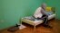 A man who fled persecution in Chechnya due to his sexual orientation sits on his bed in Moscow.